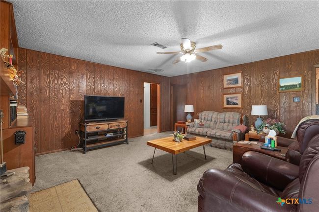 Living room with wood-burning fireplace and built-in bookcase | Image 11