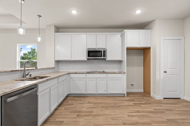 Kitchen with stainless steel appliances, a sink, backsplash, white cabinets, and recessed lighting | Image 17
