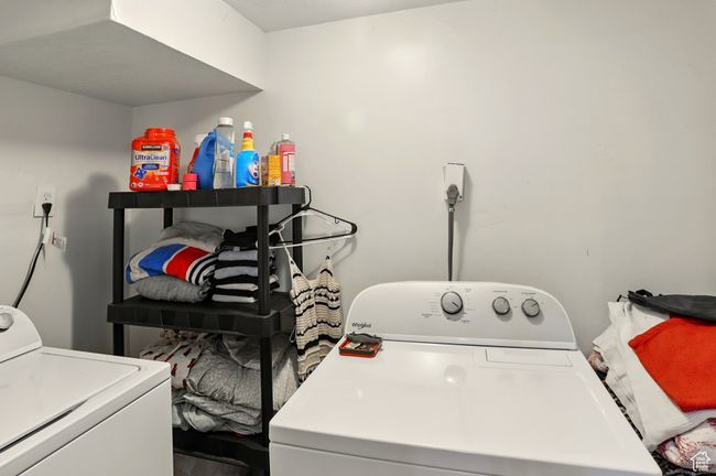 Laundry room with separate washer and dryer and wood finished floors | Image 24