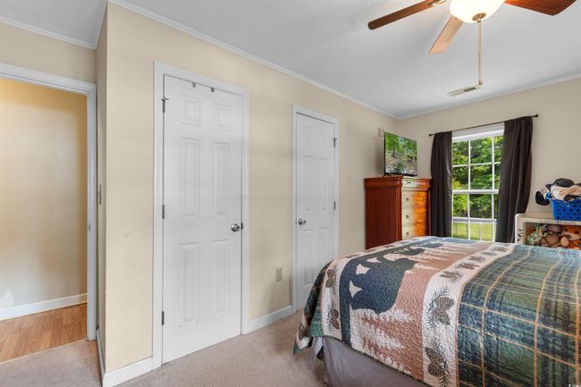 Bedroom with light carpet, ceiling fan, and ornamental molding | Image 16
