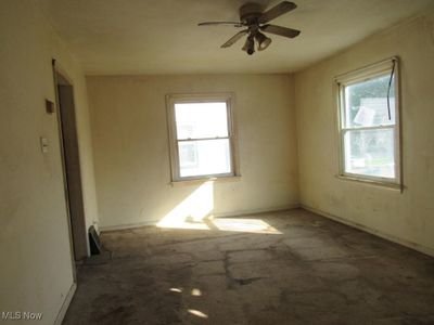 Unfurnished room featuring ceiling fan and dark colored carpet | Image 3