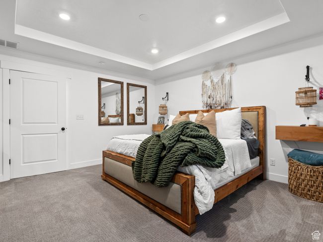 Bedroom featuring a raised ceiling, carpet flooring, and recessed lighting | Image 44