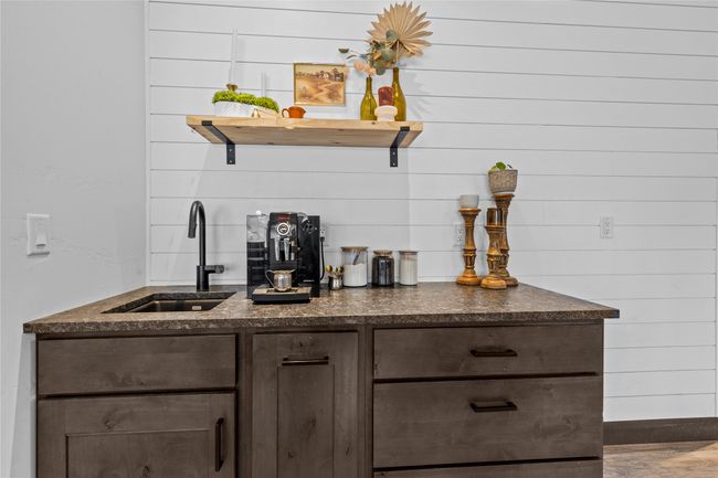 Bar featuring wood finished floors, baseboards, and a sink | Image 7