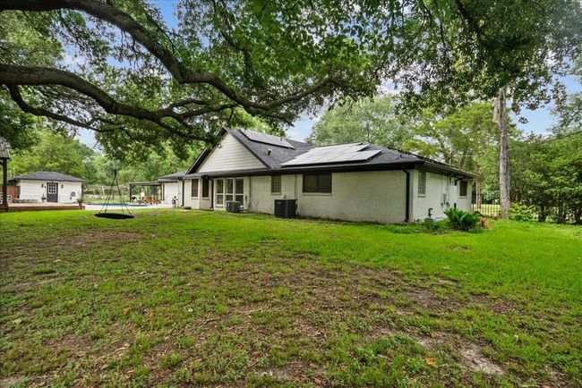 Shaded backyard with solar panels, swing, and pool access—perfect for relaxing or play. | Image 46