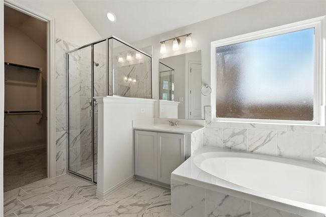 Bathroom with a bath, marble look tile flooring, a shower stall, and vanity | Image 23