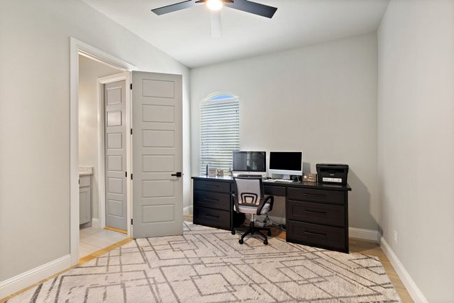 Office featuring a ceiling fan, baseboards, light wood-style floors, and vaulted ceiling | Image 25