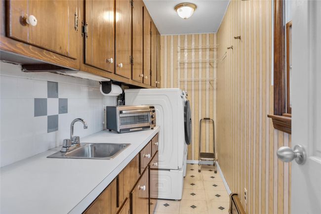 Laundry room with cabinet space, a sink, a toaster, and light floors | Image 20