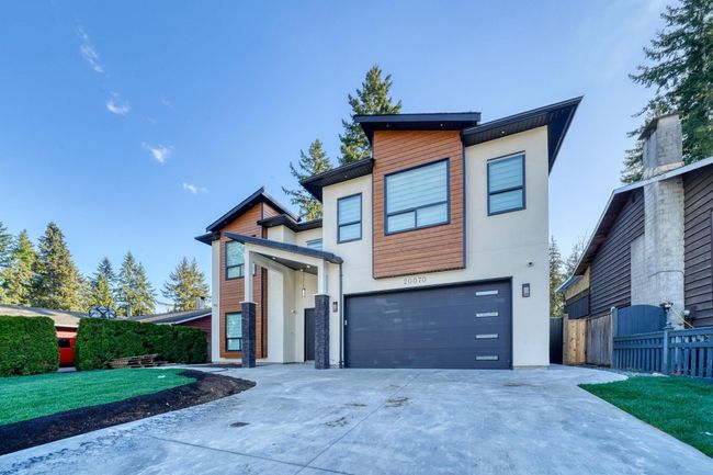Contemporary house with an attached garage, concrete driveway, and stucco siding | Image 30