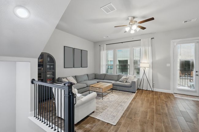 Living room with visible vents, baseboards, ceiling fan, and dark wood-style floors | Image 13
