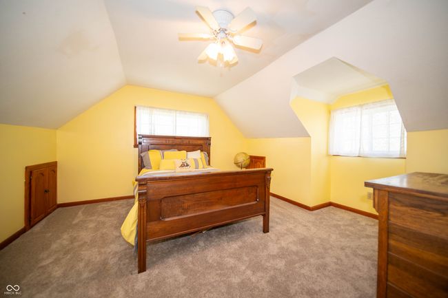 Cheerful bedroom featuring vaulted ceiling, multiple windows, and carpet flooring. | Image 17