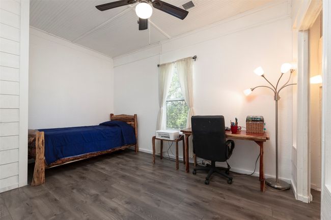 Bedroom featuring wood finished floors, an office area, and ceiling fan | Image 17