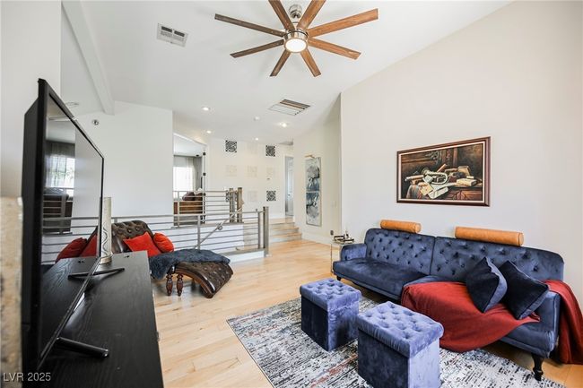 Living room with wood finished floors, baseboards, a ceiling fan, and visible vents | Image 40