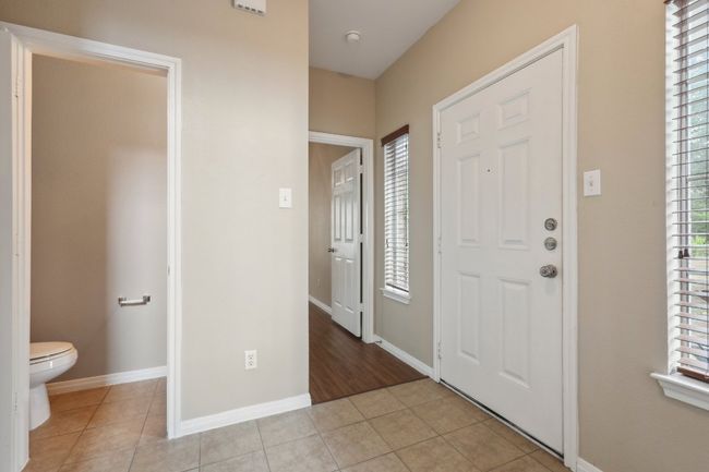 Entrance foyer with baseboards, a healthy amount of sunlight, and light tile patterned flooring | Image 16