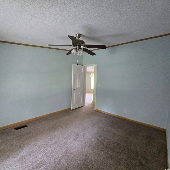 Carpeted spare room with ceiling fan, ornamental molding, and a textured ceiling | Image 27