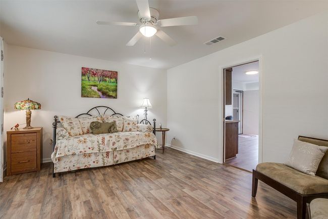 Bedroom with wood finished floors and a ceiling fan | Image 9
