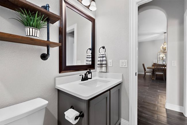 Half bathroom with toilet, baseboards, vanity, wood finished floors, and a textured wall | Image 33
