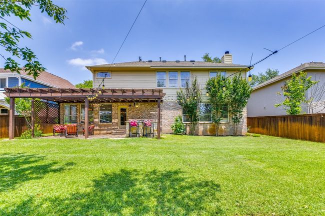 Rear view of property featuring a pergola, a chimney, a patio area, and brick siding | Image 24