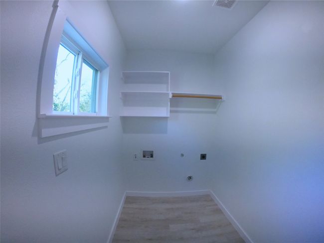 Clothes washing area with hookup for an electric dryer, light wood-style flooring, baseboards, gas dryer hookup, and laundry area | Image 14