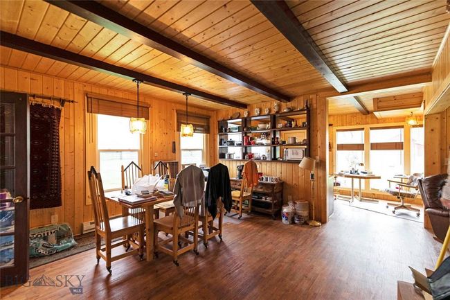 Dining area featuring dark hardwood / wood-style flooring, wooden walls, wooden ceiling, a notable chandelier, and beamed ceiling | Image 26