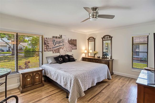 Bedroom featuring baseboards, light wood-type flooring, ornamental molding, and a ceiling fan | Image 34