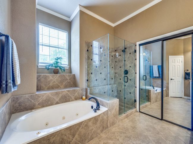 Full bath with a stall shower, a whirlpool tub, crown molding, and tile patterned flooring | Image 20