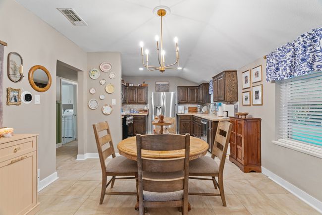 Dining space with a chandelier, light tile patterned floors, and vaulted ceiling | Image 10