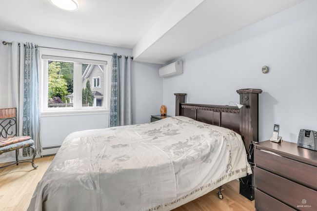 Bedroom featuring a wall mounted AC and light wood-type flooring | Image 23