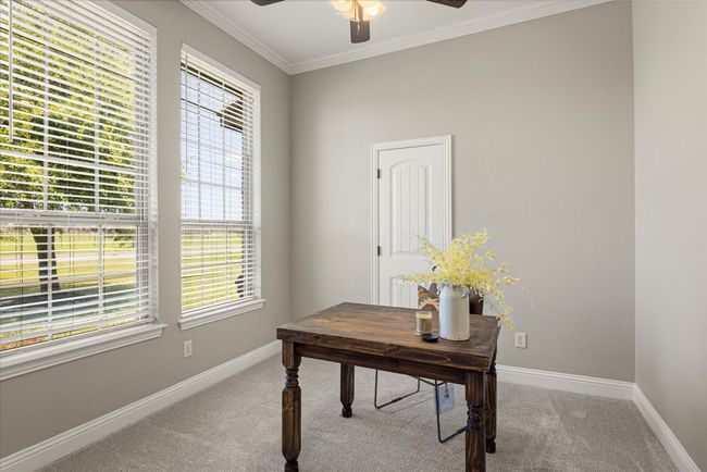 Home office featuring carpet flooring, a ceiling fan, and crown molding | Image 28