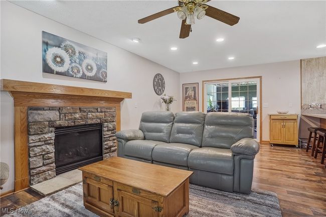 Living room with recessed lighting, ceiling fan, wood finished floors, and a fireplace | Image 8