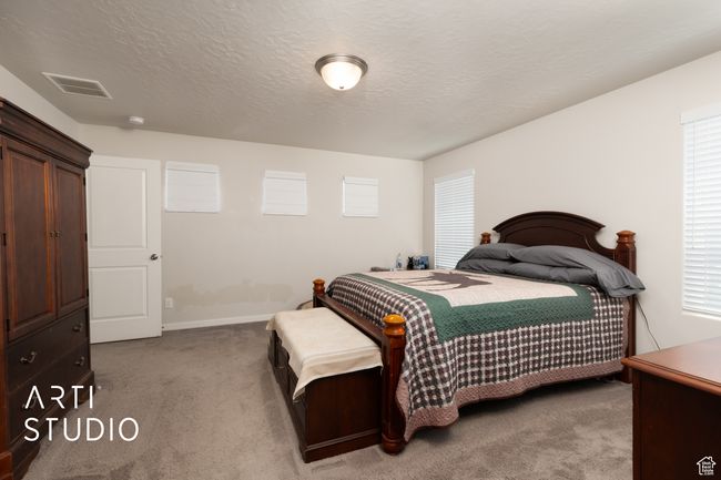 Carpeted bedroom featuring a textured ceiling and baseboards | Image 15