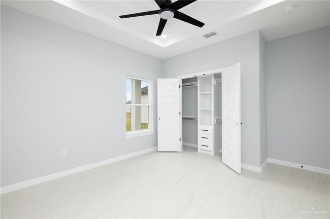 Unfurnished bedroom featuring a raised ceiling, baseboards, a closet, a ceiling fan, and recessed lighting | Image 13