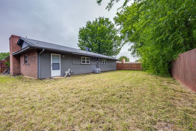 Back of property with a chimney, central AC unit, and brick siding | Image 23