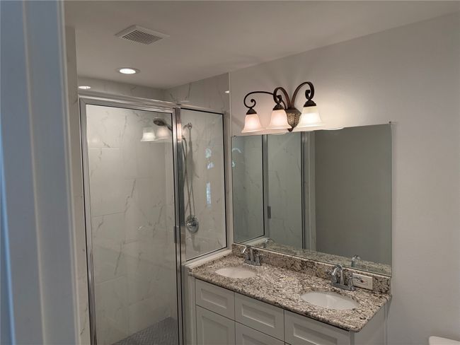 Full bath featuring a marble finish shower and double vanity | Image 14