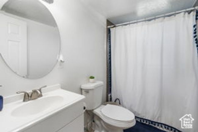 Bathroom featuring toilet, vanity, and a shower with shower curtain | Image 23