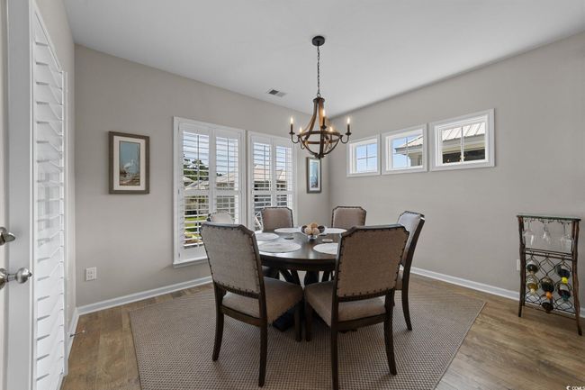 Dining space with a chandelier, wood finished floors, and baseboards | Image 8