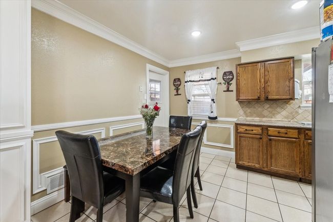 Dining area featuring light tile patterned floors, crown molding, and recessed lighting | Image 20