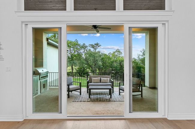 Glass sliders leading to back patio with outdoor kitchen. | Image 7