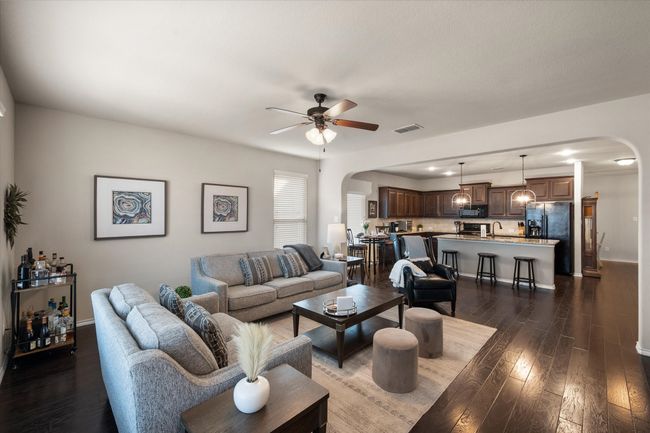 Living room with arched walkways, visible vents, dark wood finished floors, and ceiling fan | Image 23