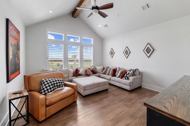 First floor game room featuring ceiling fan, visible vents, beam ceiling, and wood finished floors | Image 22