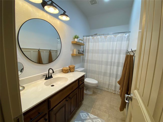 Bathroom featuring toilet, tile patterned flooring, tub/shower, and vanity | Image 7