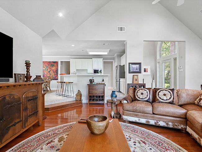 Living room (facing kitchen) with high vaulted ceiling and wood finished floors | Image 9