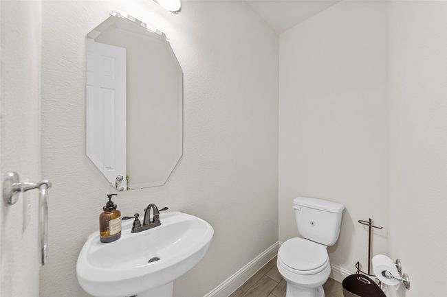 Half bath with a sink, toilet, baseboards, and wood finished floors | Image 6