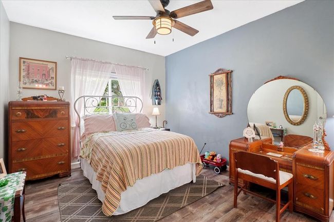 Bedroom featuring access to exterior, wood finished floors, baseboards, and ceiling fan | Image 9