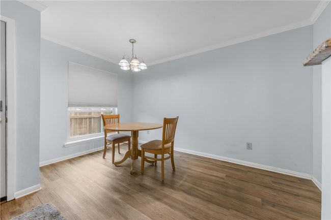 Dining room with ornamental molding, a chandelier, and wood finished floors | Image 8
