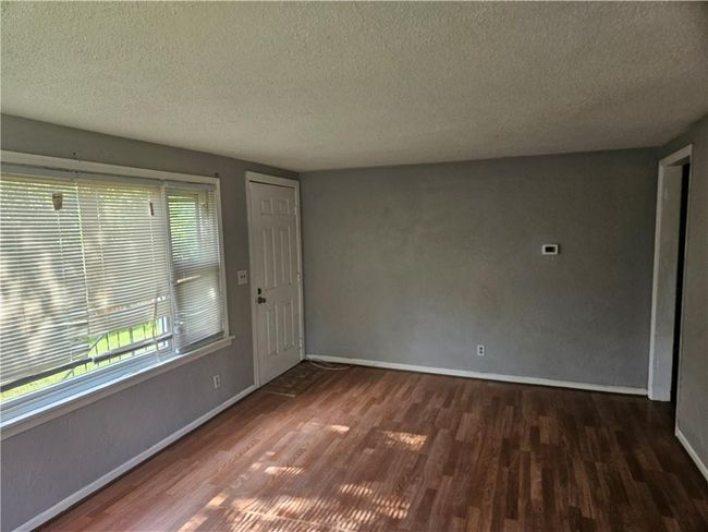 Empty room with wood finished floors and a textured ceiling | Image 8