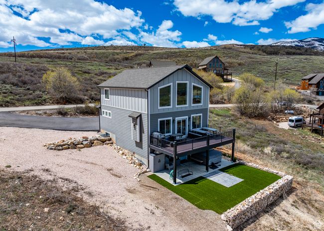 Rear view of house featuring a patio, a shingled roof, board and batten siding, and a deck with mountain view | Image 53