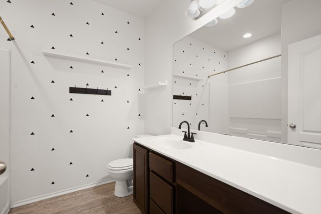 Full bath featuring vanity, wood finished floors, toilet, baseboards, and walk in shower | Image 7