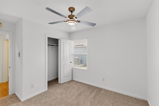 Unfurnished bedroom featuring light carpet, baseboards, a closet, and a ceiling fan | Image 26