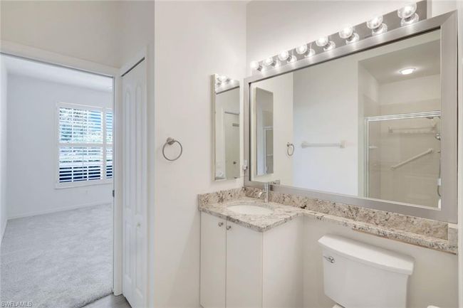 Bathroom featuring vanity, toilet, and a shower with door | Image 15