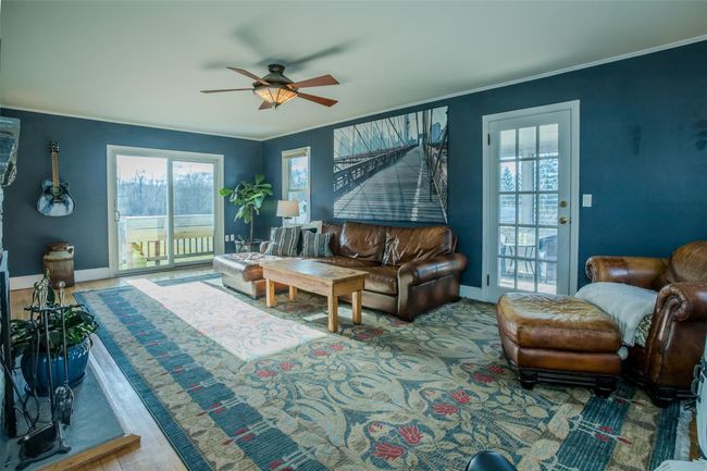 Living room featuring wood-type flooring and ceiling fan | Image 5